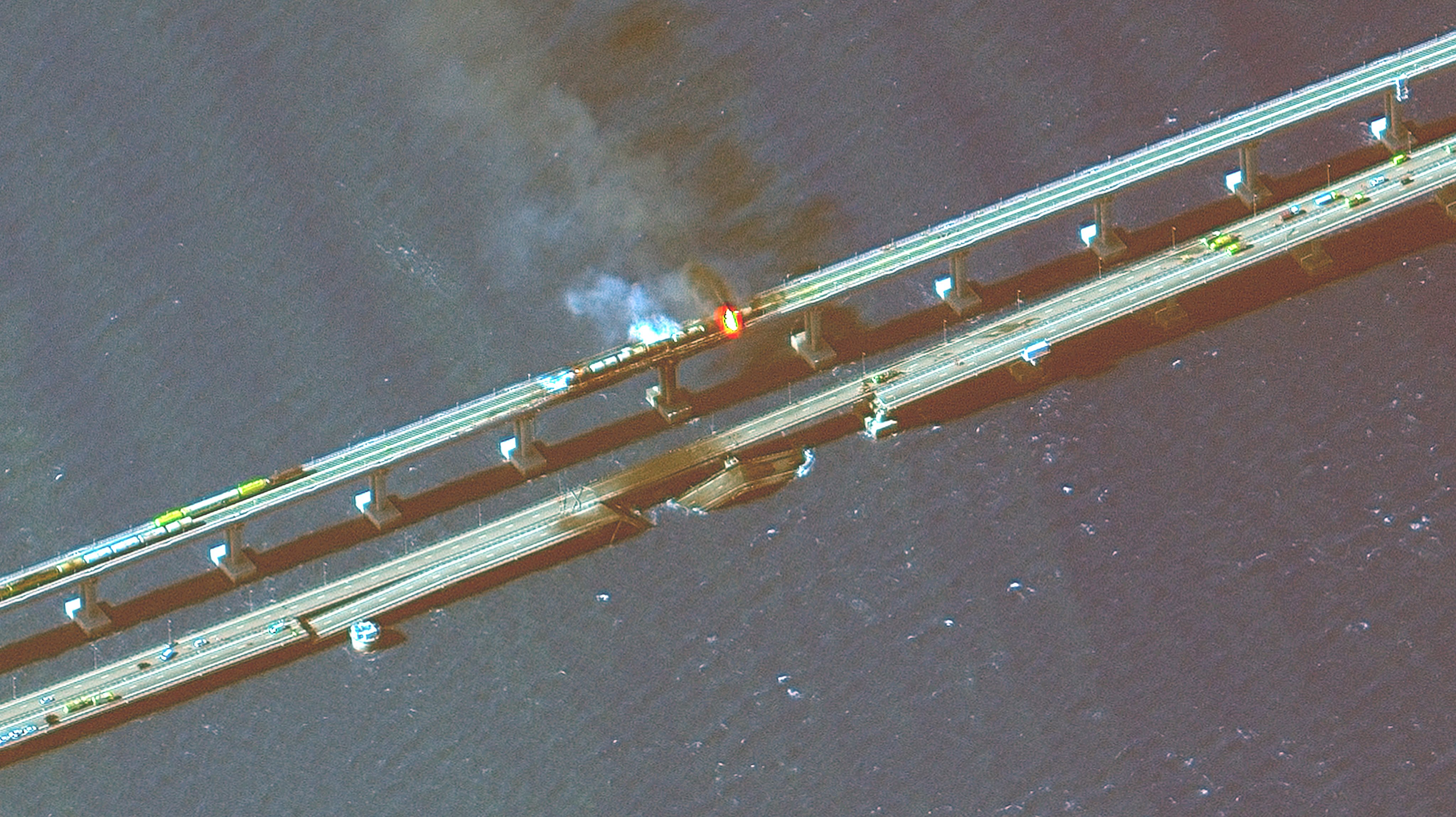 KERCH BRIDGE, CRIMEA -- OCTOBER 8, 2022:  04 Maxar infra-red closeup satellite imagery of burning rail cars and the damage to the Kerch Bridge in Crimea.  Please use: Satellite image (c) 2022 Maxar Technologies.