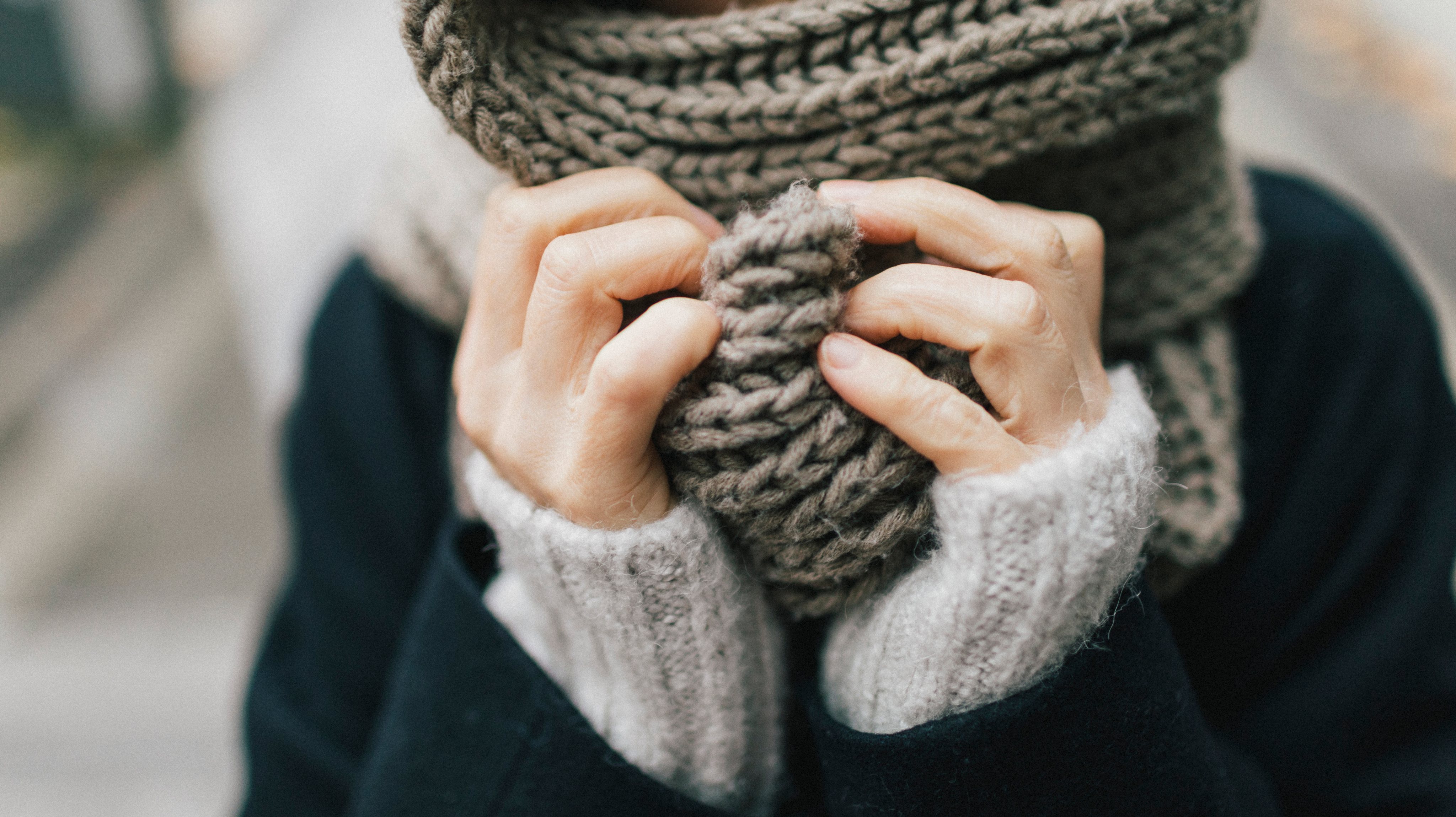 Woman&#039;s hand holding knitted scarf, close-up