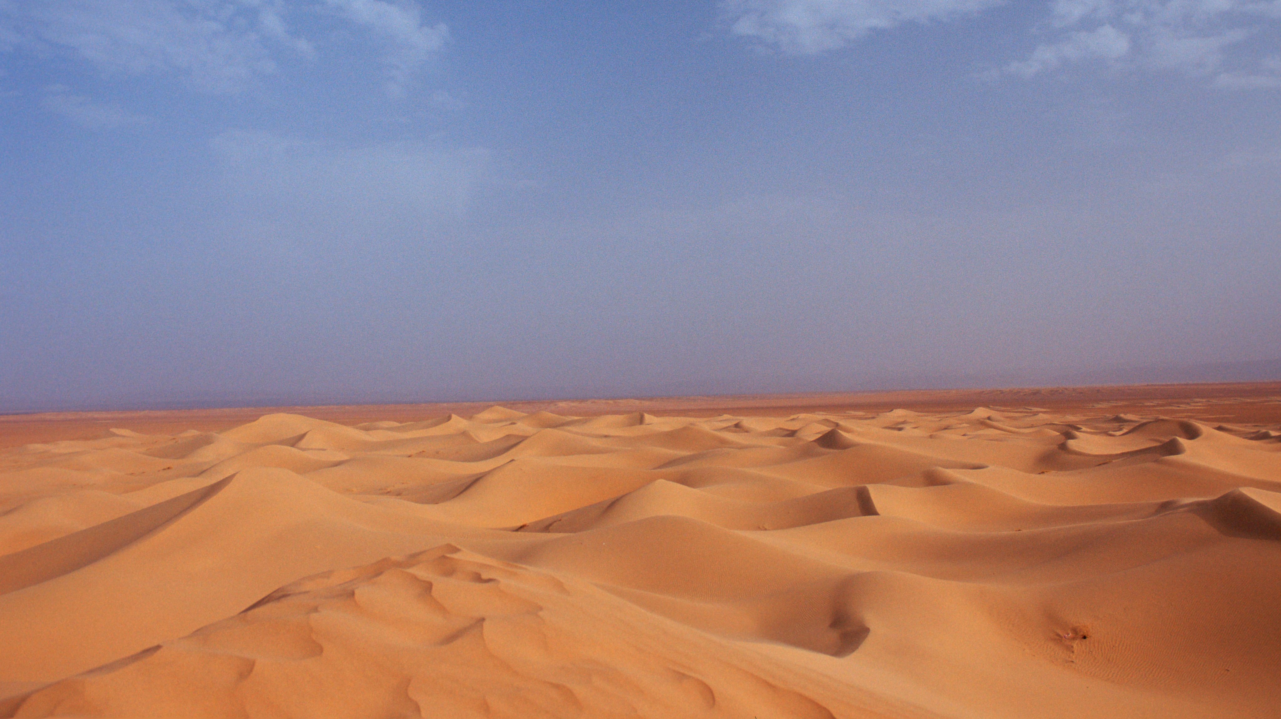 Quão profunda é a camada de areia no Deserto do Saara? O que existe abaixo  desta camada? É uma transição gradual, ou trata-se de areia pura em cima de  uma superfície plana? 