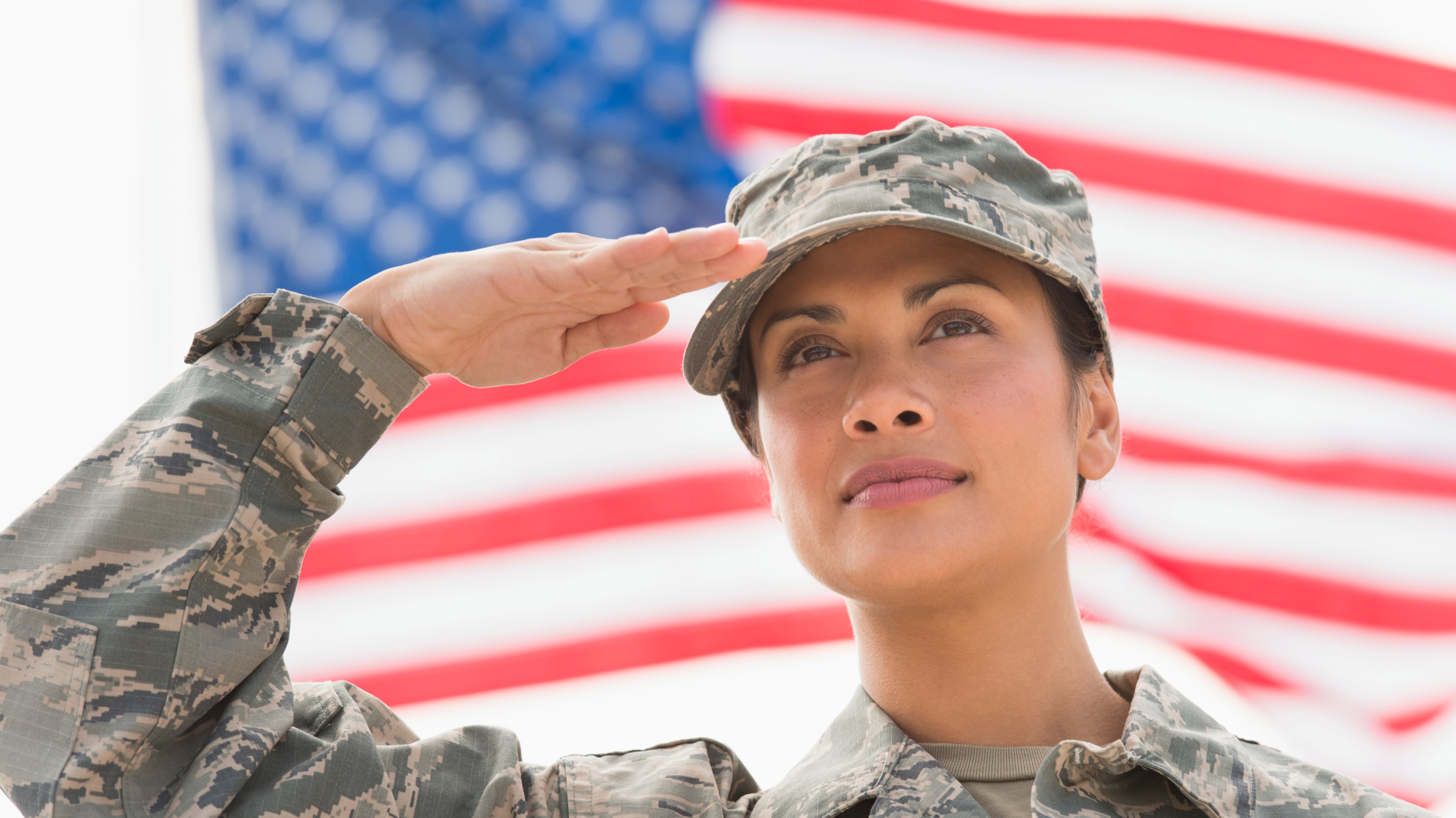 USA, New Jersey, Jersey City, Female army soldier saluting, American flag in background