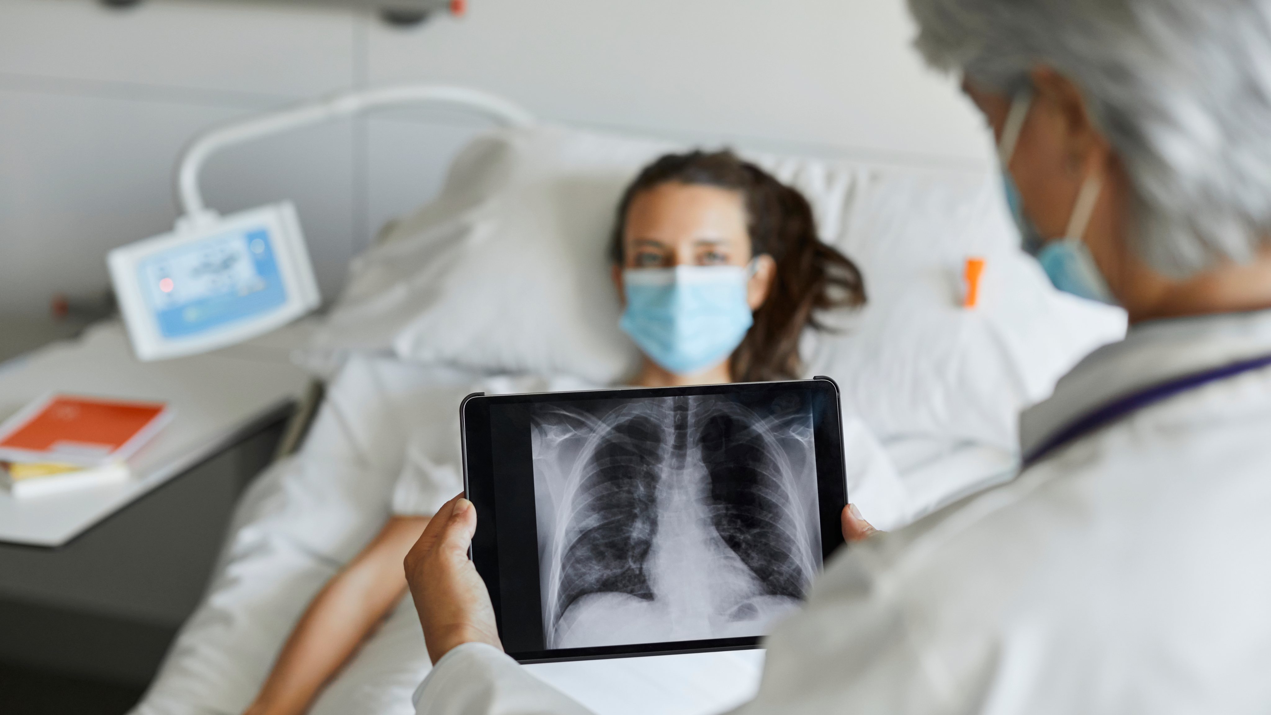 Doctor with digital x-ray by patient in ICU