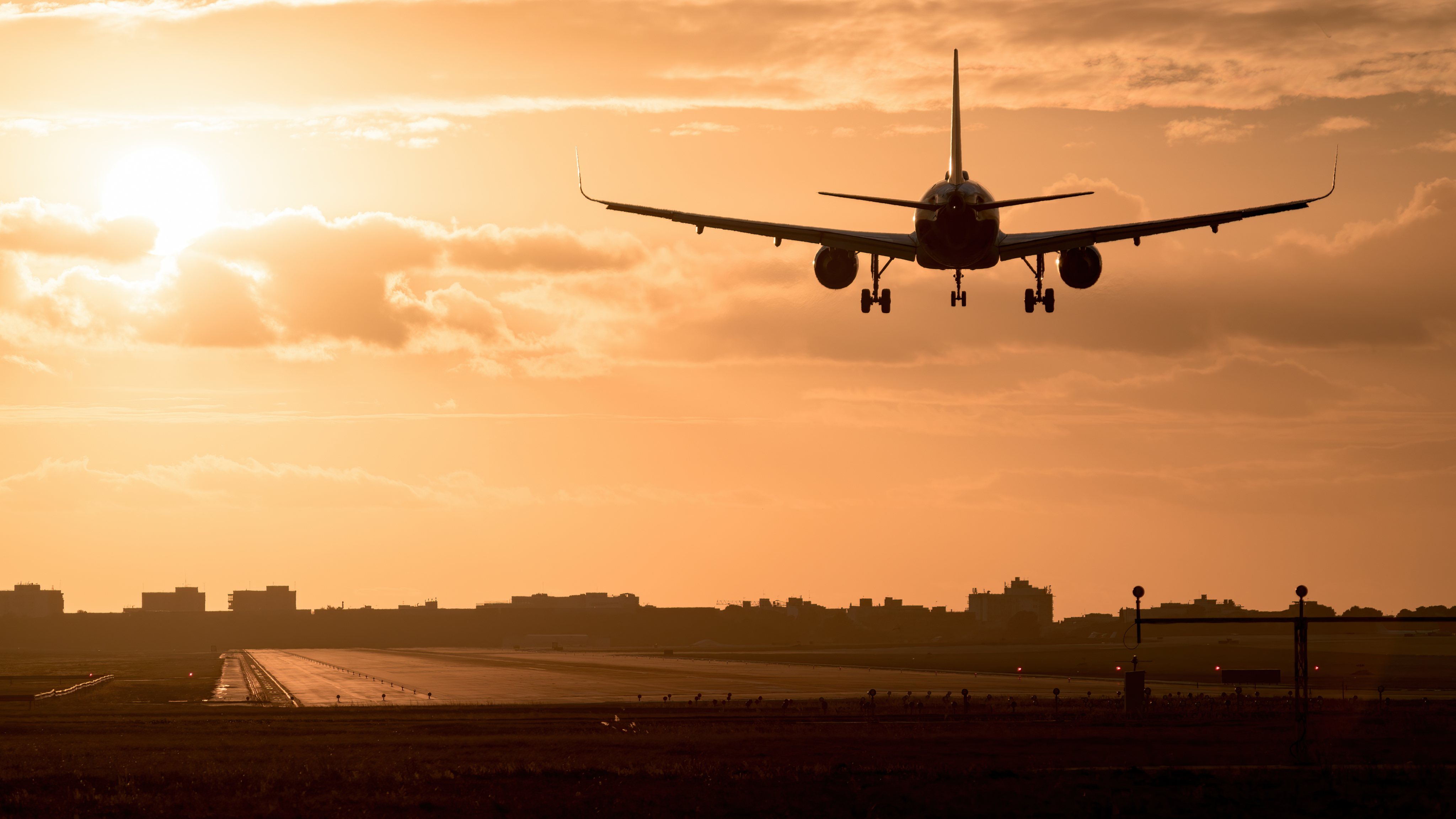 Airplane landing at sunset, sunsets background, travel background