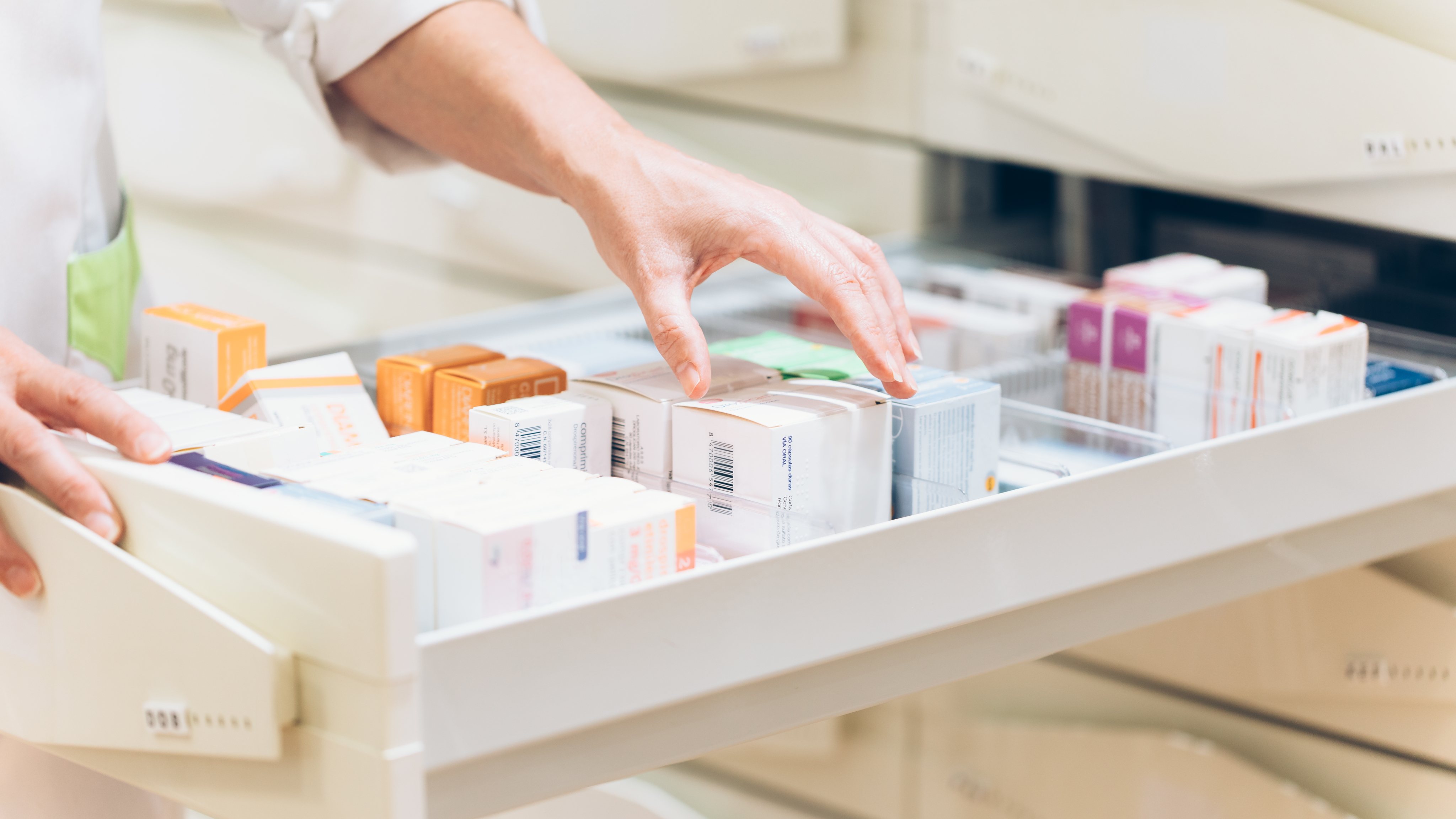 Pharmacist hand taking medication from drawer