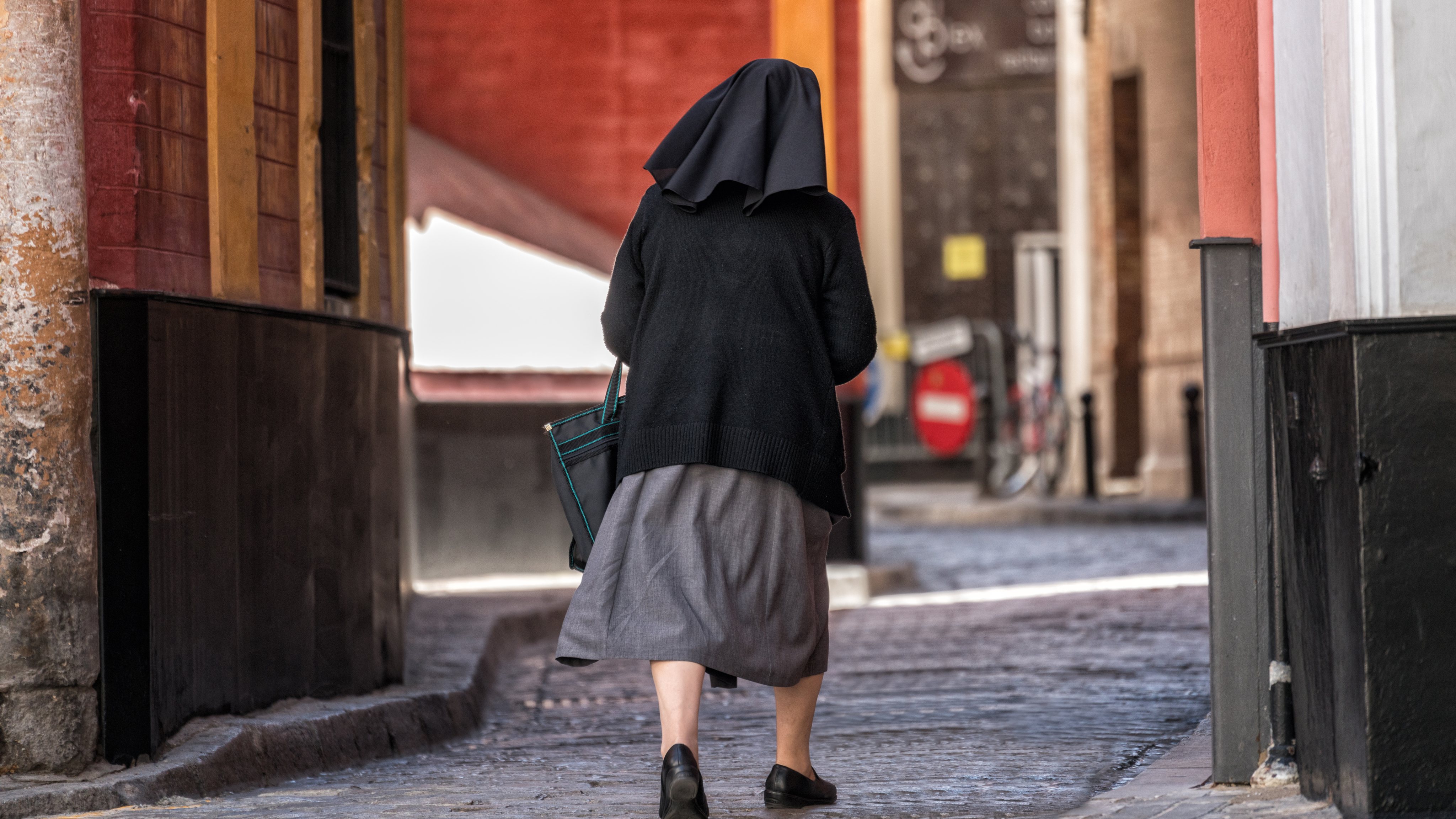 Rear View Of Nun Walking On City Street