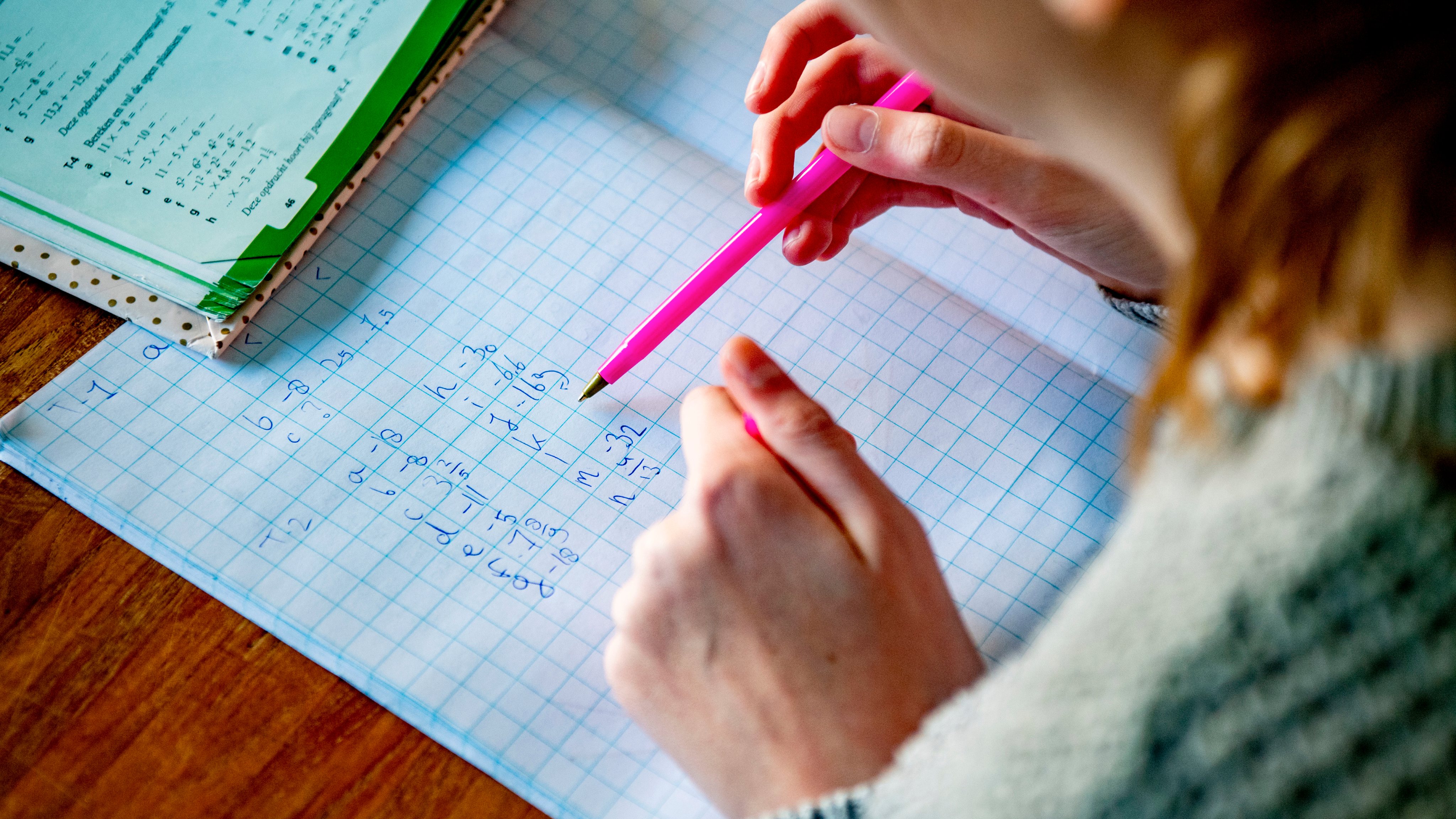 A female student does her mathematics exercises at her home