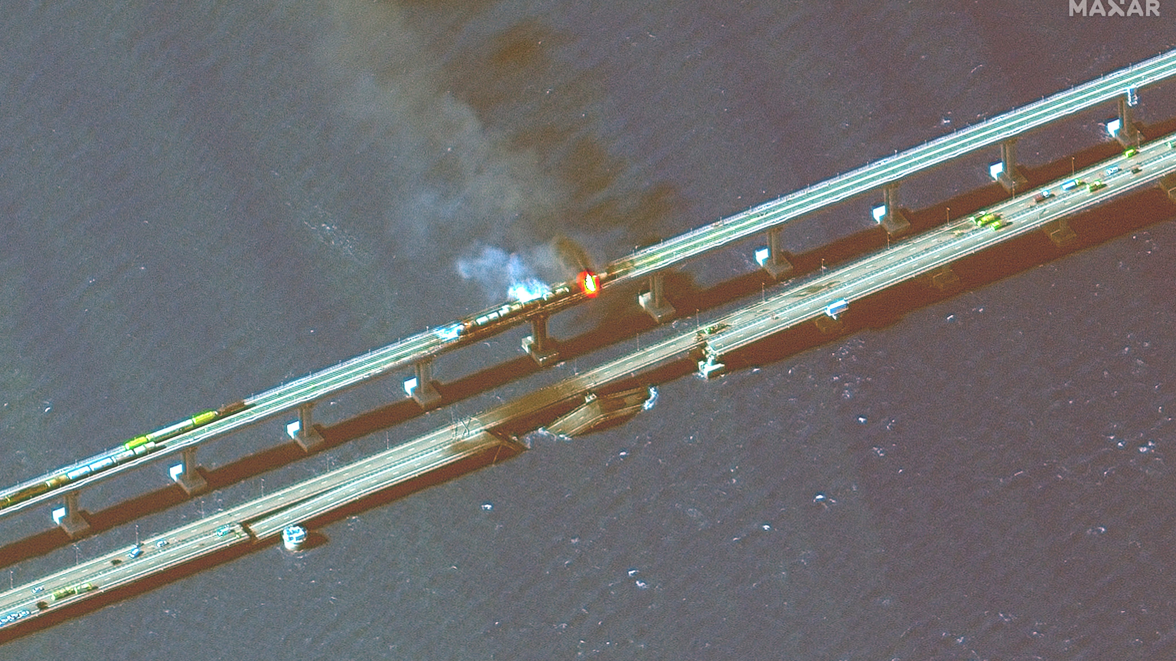 KERCH BRIDGE, CRIMEA -- OCTOBER 8, 2022:  04 Maxar infra-red closeup satellite imagery of burning rail cars and the damage to the Kerch Bridge in Crimea.  Please use: Satellite image (c) 2022 Maxar Technologies.