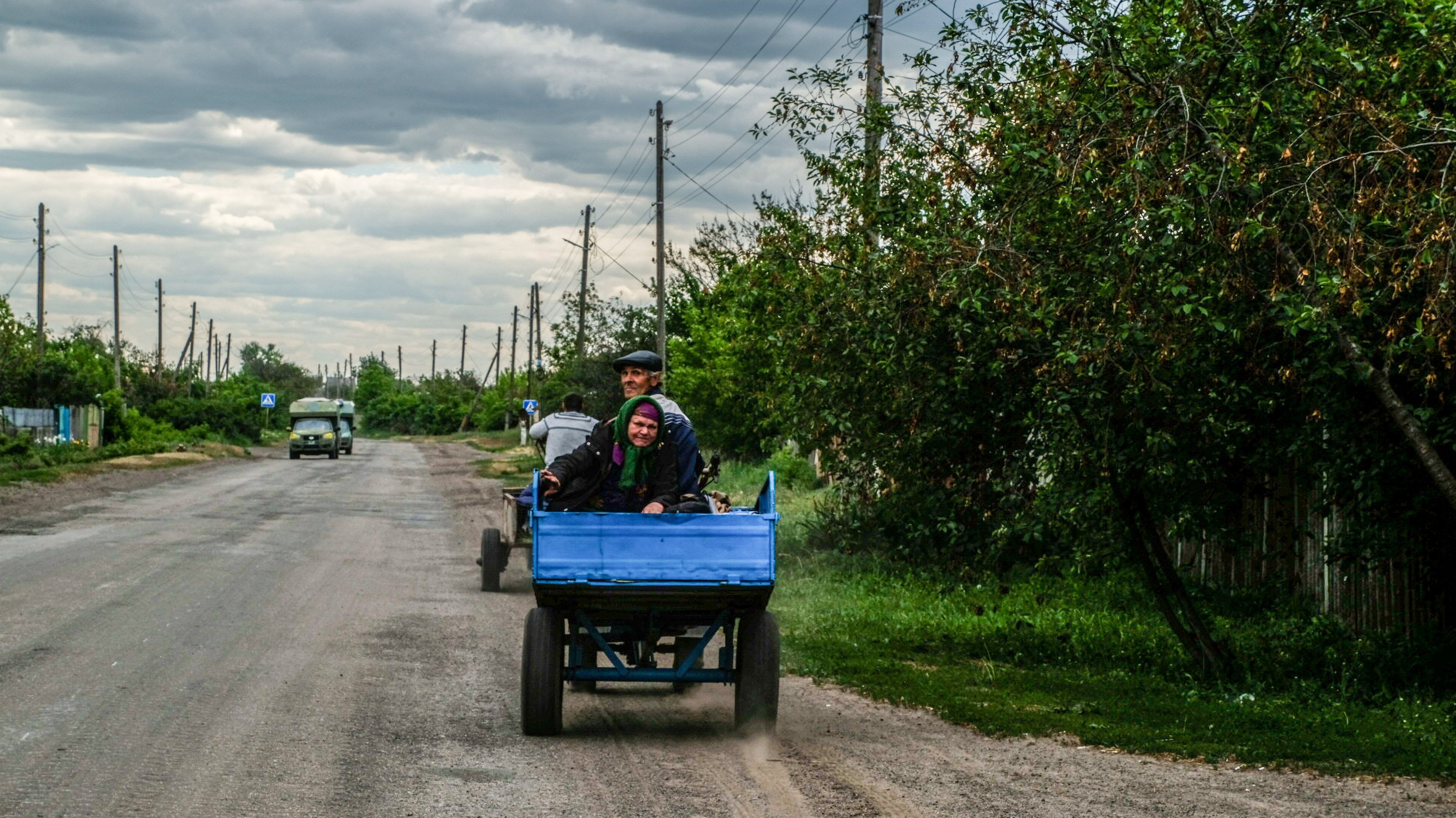 A couple drives to collect food and water on a road between
