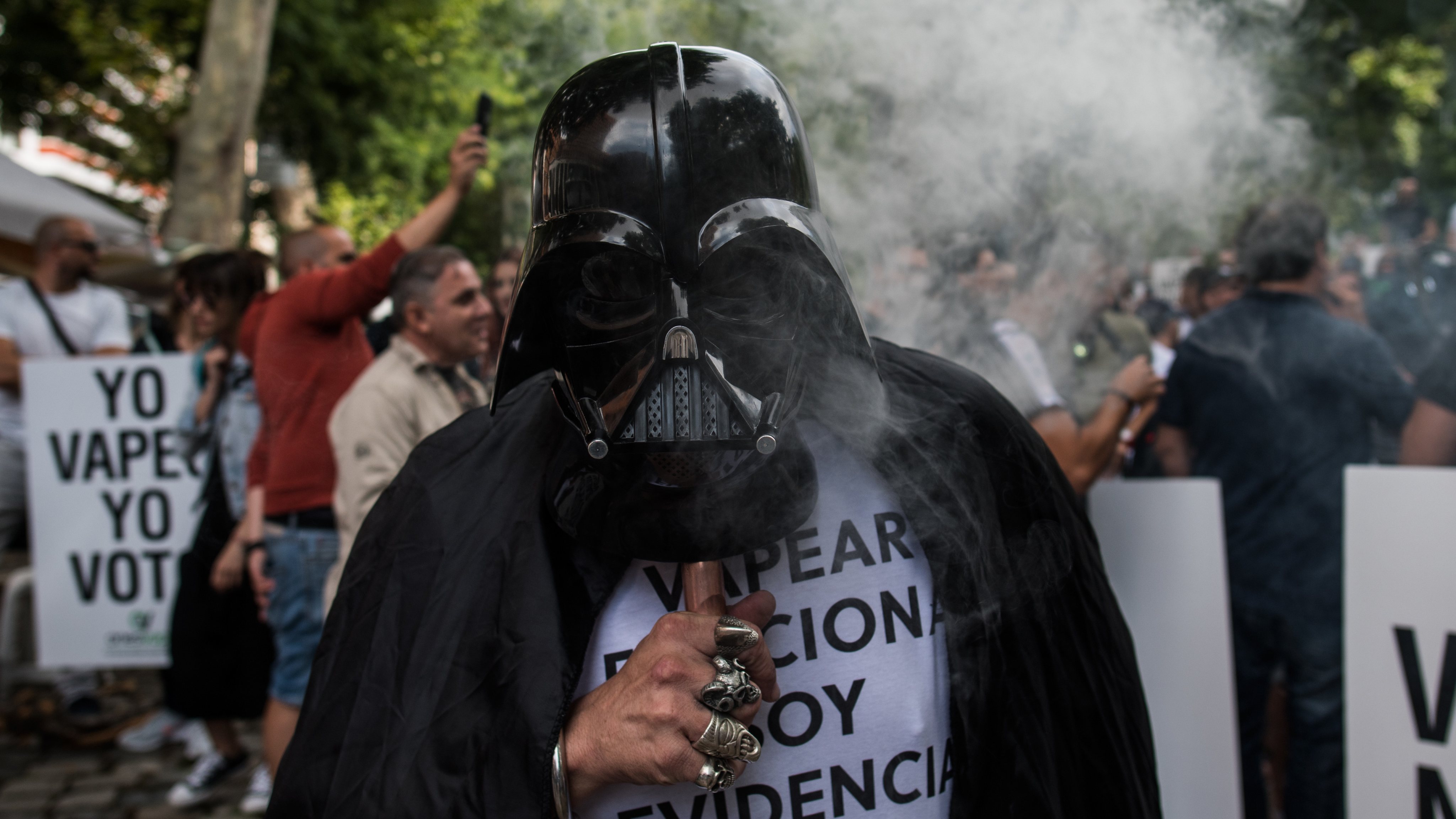 A man with a Darth Vader mask vaping in front of the