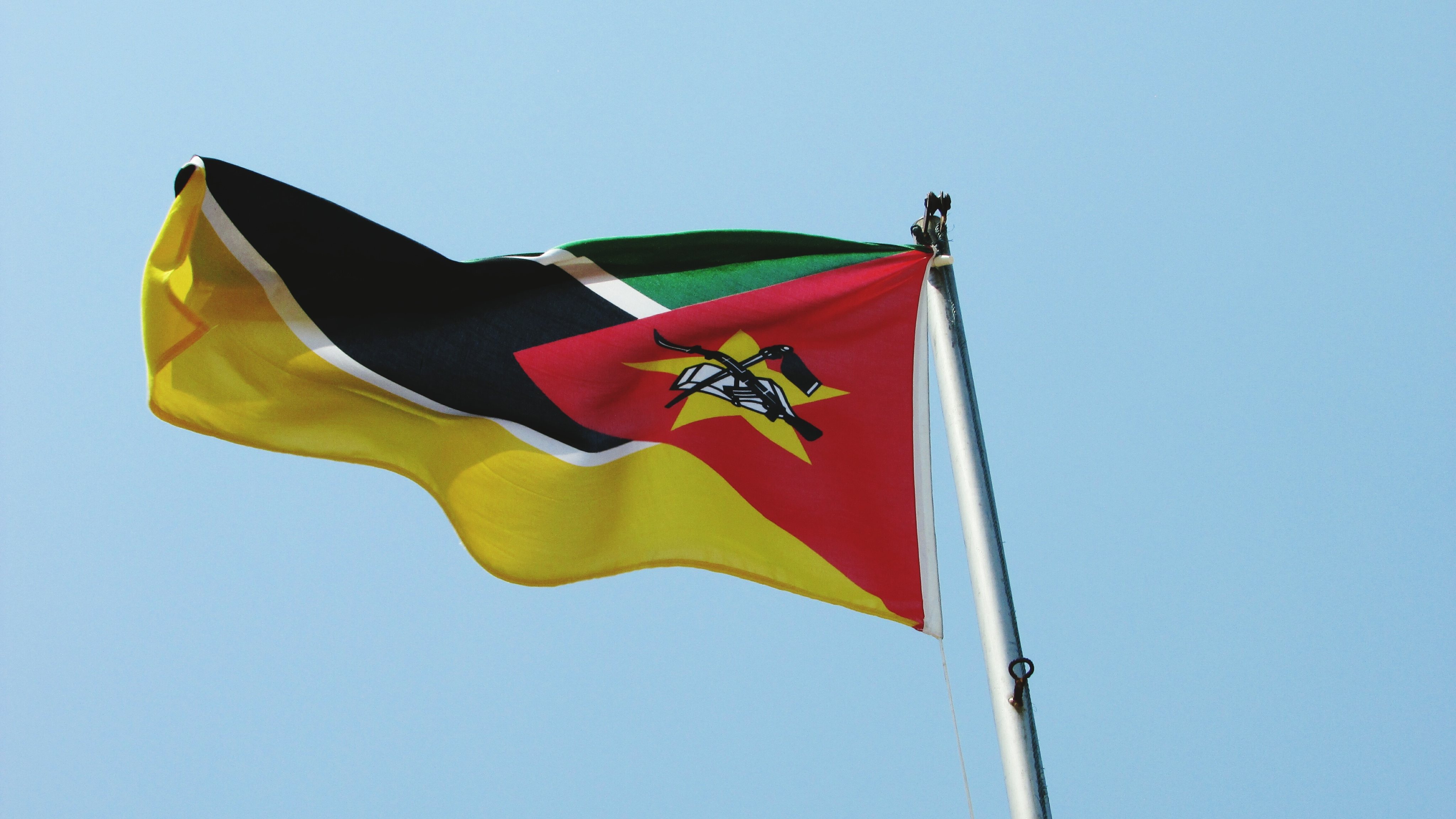 Low Angle View Of Mozambique Flag Against Clear Sky