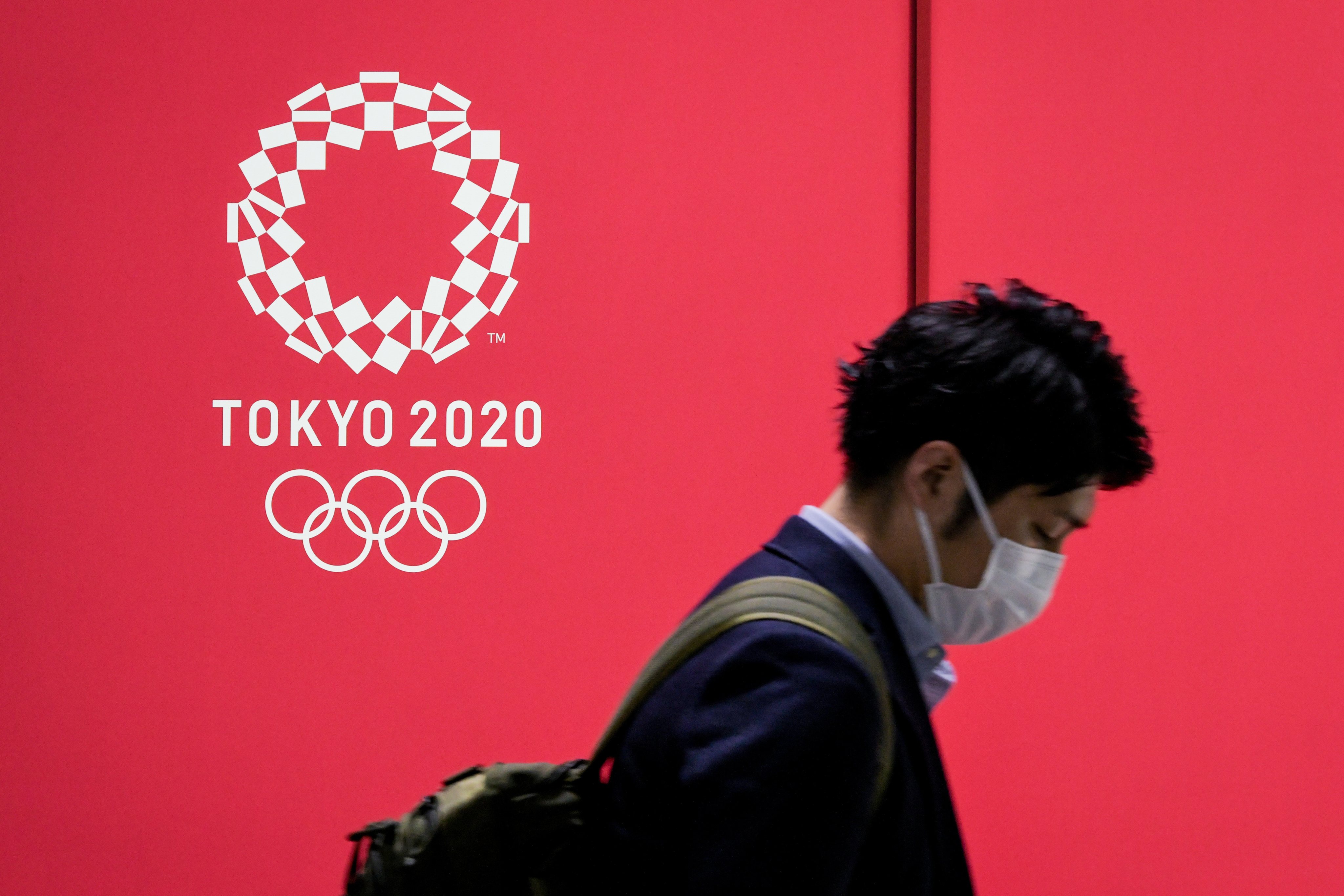 A man walks past a Tokyo 2020 advertising poster at the