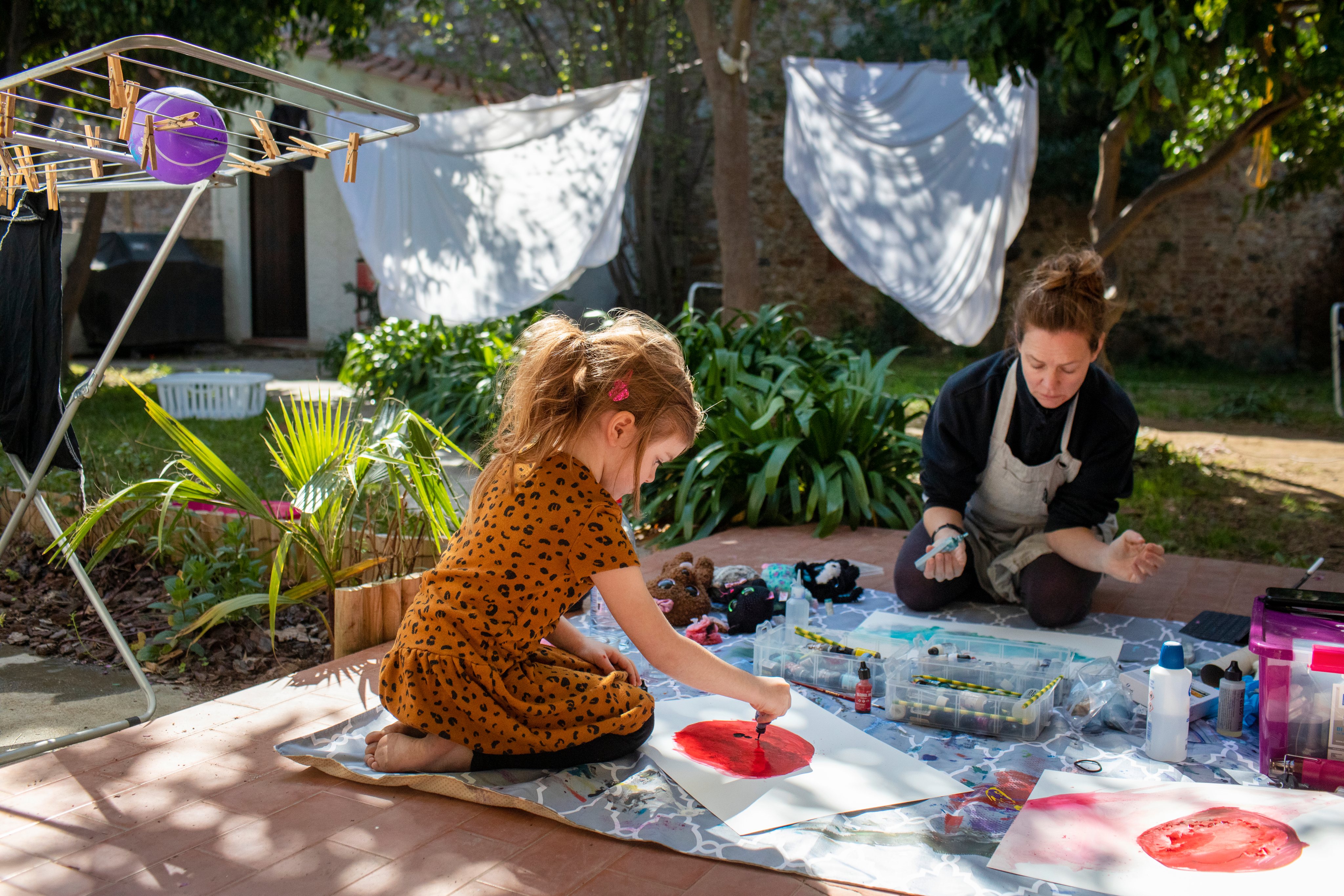 A mother and daughter performing artwork during home schooling.