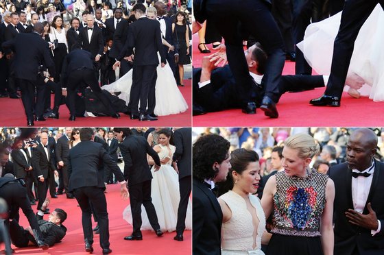 A combination of pictures made on May 17, 2014 shows prankster Vitalii Sediuk blocked by minders as he tries to slip under US actress America Ferrera's dress as she arrives for the screening of the animated film "How to train your Dragon 2" at the 67th edition of the Cannes Film Festival in Cannes, southern France, on May 16, 2014.   AFP PHOTO        (Photo credit should read VALERY HACHE,ALBERTO PIZZOLI,LOIC VENANCE/AFP/Getty Images)