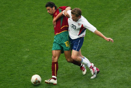 SUWON - JUNE 5:  Rui Costa of Portugal (left) is challenged by Brian McBride of the USA during the first half during the Portugal v USA, Group D, World Cup Group Stage match played at the Suwon World Cup Stadium, Suwon, South Korea on June 5, 2002. USA won the match 3 - 2. (Photo by Ben Radford/Getty Images)