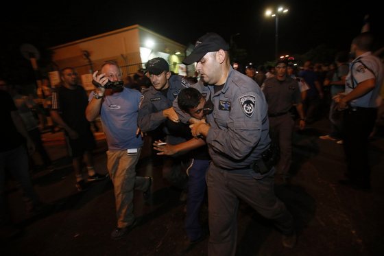 An Isaeli supporter of the right-wing Organization for Prevention of Assimilation in the Holy Land (LEHAVA) is detained by police during a demonstration outside the wedding hall where Mahmoud Mansour, an Arab-Israeli, and Morel Malcha, a Jewish, got married on August 17, 2014 in the Israeli costal city of Rishon Letzion.  AFP PHOTO/GALI TIBBON        (Photo credit should read GALI TIBBON/AFP/Getty Images)