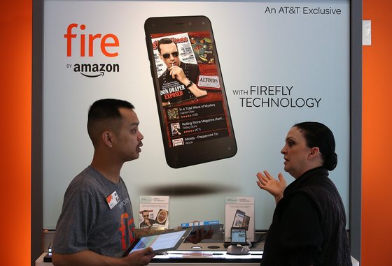 SAN FRANCISCO, CA - JULY 25:  An AT&T worker helps a customer with information on the new Amazon Fire phone at an AT&T store on July 25, 2014 in San Francisco, California.  Amazon's Fire phone is going on sale today at AT&T stores for $199 with a two-year AT&T contract or $649 without a contract. The phone features a year of Amazon Prime service, Dynamic Perspective 3D imaging and Firefly image recognition that allows users to scan objects and purchase the item from Amazon's online shopping site.  (Photo by Justin Sullivan/Getty Images)
