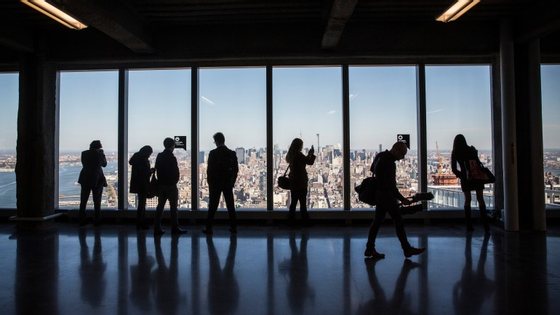 NEW YORK, NY - NOVEMBER 03:  Members of the media explore a model office, used to exhibit what a business space could look like on the 63rd floor of  One World Trade Center, which opens for business today, on November 3, 2014 in New York City. The skyscraper is 104 stories tall and cost $3.9 billion; it opens more than 13 years after the terrorist attacks of September 11, 2001, destroyed the original World Trade Center buildings. Officials say the building is currently at 60% occupancy, with Conde Nast as one of the first major tenants to move in.  (Photo by Andrew Burton/Getty Images)