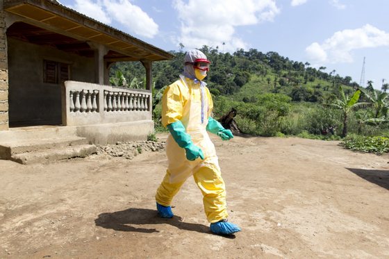 An health worker from Guinea's Red Cross wearing a Personal Protective Equipments (PPE) leaves the house of a victim of the Ebola virus in Patrice disitrict in Macenta, in Guinea on November 21, 2014.  The deadliest Ebola epidemic on record has killed more than 5,000 people in west Africa and infected almost three times that number, according to the World Health Organization. The virus emerged in Guinea at the start of the year and has infected around 1,900 Guineans, killing almost 1,200. AFP PHOTO KENZO TRIBOUILLARD        (Photo credit should read KENZO TRIBOUILLARD/AFP/Getty Images)