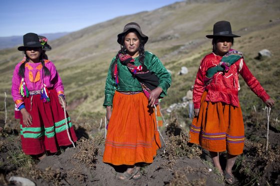 Andean girls pose for a picture during the harvest of native potatoes in the Pomacochas district of  the department of Apurimac, 900 kms southeast from Lima on May 26, 2014. Peru is the country with the greatest diversity of potatoes in the world, with some 3,800 types, differing in size, shape, color, skin, pulp, texture and  taste,  all of which have their place in Peruvian cuisine.   AFP PHOTO/ERNESTO BENAVIDES        (Photo credit should read ERNESTO BENAVIDES/AFP/Getty Images)