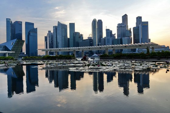 A general view of the financial district skyline is reflected in a pond in Singapore on March 6, 2014 in Singapore. Singapore played down a global survey showing that it is now the world's most expensive city, a finding which has triggered outrage among Singaporeans struggling with rising costs. AFP PHOTO / ROSLAN RAHMAN        (Photo credit should read ROSLAN RAHMAN/AFP/Getty Images)