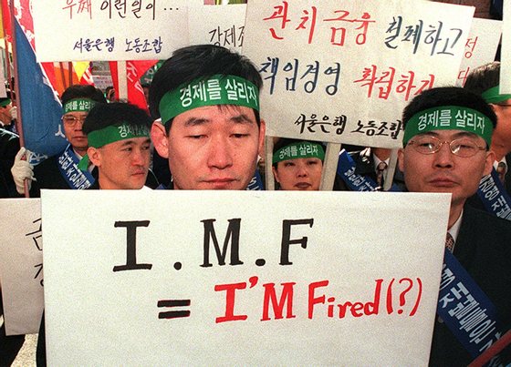 SEOUL, SOUTH KOREA:  A South Korean labor union member of Seoulbank, one of South Korea's most bad-debt burdened commercial banks, looks downcast while holding placard as the members fanned out over the city urging South Koreans to help save the economy by shunning imports in Seoul 02 December. Reports say that the International Monetary Fund is pushing for the opening of South Korea's financial market and banking business as part of the massive IMF bailout.  AFP  PHOTO (Photo credit should read CHOO YOUN-KONG/AFP/Getty Images)