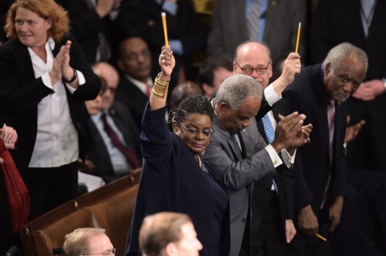 US lawmakers pay tribute to the victims of the Paris attacks by holding up pencils during the State of the Union address by US President Barack Obama, before a joint session of Congress on January 20, 2015 at the US Capitol in Washington, DC.   AFP PHOTO/JIM WATSON        (Photo credit should read JIM WATSON/AFP/Getty Images)