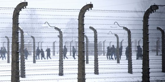 Visitor are seen walking behind barbed-wire fences at the memorial site of the former Nazi concentration camp Auschwitz-Birkenau in Oswiecim, Poland on January 25, 2015, days before the 70th anniversary of the liberation of the camp by Russian forces. AFP PHOTO / JOEL SAGET (Photo credit should read JOEL SAGET/AFP/Getty Images)