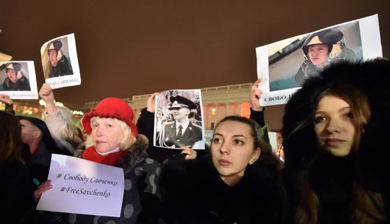 People hold pictures of first lieutenant of Ukrainian airforce, helicopter pilot Nadiya Savchenko  and placards reading "Free Savchenko" during a rally in Independence Square in Kiev, on January 26, 2015 demanding her liberation by Russia. Savchenko was fighting in a Ukrainian volunteer battalion in east of the country when she was captured by pro-Russian insurgents in eastern Ukraine and later handed over to Russia, where she is being charged with complicity in the deaths of two Russian journalists during the 2014 insurgency in Donbass. AFP PHOTO/ SERGEI SUPINSKY        (Photo credit should read SERGEI SUPINSKY/AFP/Getty Images)