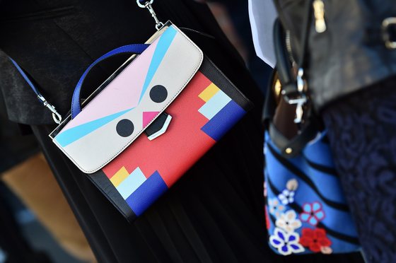 A woman poses with a Fendi bag in the street before the show for fashion house Fendi at the women Fall / Winter 2015/16 Milan's Fashion Week on February 26, 2015.   AFP PHOTO / GABRIEL BOUYS        (Photo credit should read GABRIEL BOUYS/AFP/Getty Images)