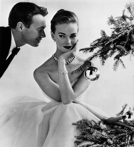 A couple flirting beside a Christmas tree, December 1955. The female model is Susan Abraham. Original Publication: Housewife Magazine - pub. 1955 (Photo by John French/Getty Images)