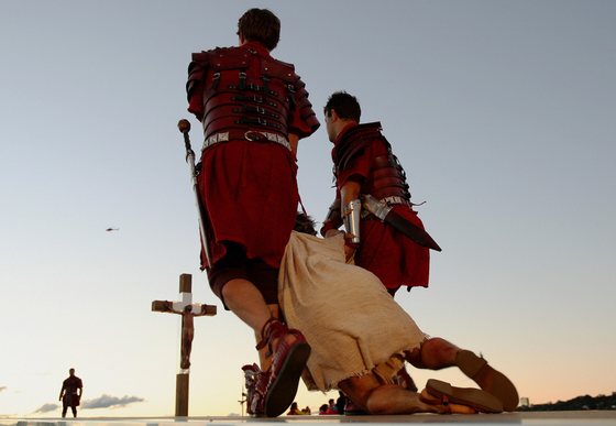 Jesus (below) is dragged to the cross during a re-enactment at World Youth Day at Barangaroo in Sydney on July 18, 2008. The "stations of the cross" re-enactment of the last days of Jesus Christ's life, was being held at some of Sydney's most famous sites and had been expected to draw between 350,000 and 450,000 spectators, organisers said.   AFP PHOTO / Greg WOOD (Photo credit should read GREG WOOD/AFP/Getty Images)