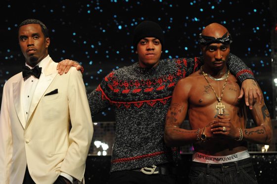 London rapper, Chip (C), poses with wax figures of US rappers Tupac Shakur (R) and P Diddy (L) at Madame Tussauds in central London on January 14, 2013 to launch a new exhibit featuring four wax figures of East and West Coast US rappers. AFP PHOTO / CARL COURT        (Photo credit should read CARL COURT/AFP/Getty Images)
