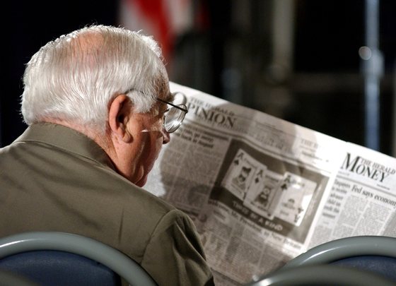 NEW BRITAIN, CT - JUNE 12:  A senior citizen reads the Money section of a newspaper while waiting for U.S. President George W. Bush to speak at New Britain General Hospital, June 12, 2003 in Connecticut. President Bush spoke to senior citizens and staff of the hospital about new Medicare legislation that would help seniors pay for prescription drugs.  (Photo by Stephen Chernin/Getty Images)