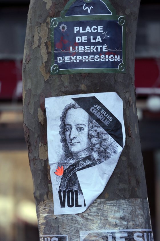 A poster that reads in French, "Square of Liberty and expression" and one showing an image of the Enlightenment writer Voltaire are plastered on a tree at the Place de la Republique, on January 11, 2015 in Paris, prior to the start of a huge march which will end at the Place de la Nation. More than a million people and dozens of world leaders were expected to march through Paris in a historic display of global defiance against extremism after Islamist attacks in Paris last week that left 17 dead. AFP PHOTO/JOEL SAGET        (Photo credit should read JOEL SAGET/AFP/Getty Images)