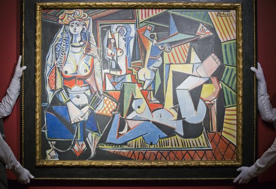 Employees of Christie's auction house hold up Spanish painter Pablo Picassos Les femmes dAlger (Version O) during a press preview in London on April 10, 2015. Les femmes dAlger (Version O), a vibrant cubist work last auctioned in 1997 when it nearly tripled the expected price, is estimated to fetch about 140 million USD at auction in New York in May, by far the highest price ever for a work of art on the auction block. AFP PHOTO / JUSTIN TALLIS RESTRICTED TO EDITORIAL USE, MANDATORY MENTION OF THE ARTIST UPON PUBLICATION, TO ILLUSTRATE THE EVENT AS SPECIFIED IN THE CAPTION        (Photo credit should read JUSTIN TALLIS/AFP/Getty Images)