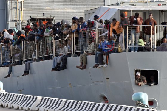 Migrants wait to disembark from a military ship following a rescue operation at sea as part of the Frontex-coordinated Operation Triton, on May 6, 2015 in Messina harbour. Italy's coastguard said it had rescued a total of 650 migrants yesterday and a total of over 1,700 were landed at various ports today as a consequence of what was one of the busiest weekends on record for rescues in the waters off Libya.  AFP PHOTO / GIOVANNI ISOLINO        (Photo credit should read GIOVANNI ISOLINO/AFP/Getty Images)