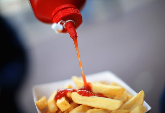 SOUTHAMPTON, ENGLAND - APRIL 26: A supporter pours ketchup on his chips ahead of  the Barclays Premier League match between Southampton and Everton at St Mary's Stadium on April 26, 2014 in Southampton, England.  (Photo by Richard Heathcote/Getty Images)