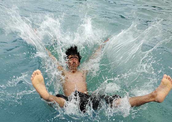 An Afghan boy dives at a swimming pool in Kabul on June 1, 2008.  Temperatures in the Afghan capital are approaching the 30 degrees Celsius mark as the summer sets in in Central Asia.   AFP PHOTO/SHAH Marai (Photo credit should read SHAH MARAI/AFP/Getty Images)