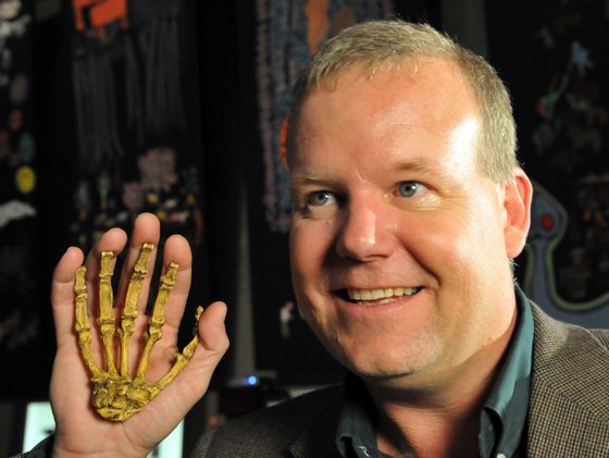 Professor Lee Berger, an American who is a professor at South Africa's University of the Witwatersrand, poses with the reconstructed hand of a hominin he discovered, during the unveiling of this Sediba Fossil in Johannesburg, on September 8, 2011. Until now, the first tool-maker was widely believed to be Homo habilis, based on a set of 21 fossilized hand bones found in Tanzania that date back 1.75 million years. However, a close examination of two partial fossilized skeletons of Au. sediba discovered in South Africa in 2008 and the new Sediba Fossil discovery suggest that these creatures who roamed the Earth 1.9 million years ago were crafting tools even earlier, and could be the first direct ancestor of the Homo species. AFP PHOTO / ALEXANDER JOE (Photo credit should read ALEXANDER JOE/AFP/Getty Images)