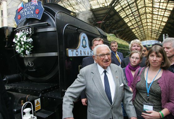 Sir Nicholas Winton (L) stands in front of a steam train with evacuees from Nazi-occupied Czechoslovakia 70 years ago, at Liverpool Street Station, in London, on September 4, 2009. A steam train carrying some of the 669 Jewish children who escaped the Holocaust thanks to a British man dubbed the "English Schindler" arrived in london on Friday after leaving Prague on Tuesday on a four-day journey to mark the 70th anniversary of the evacuations. The train traced its 1939 route via Germany and the Netherlands to London where it was met by Nicholas Winton, now aged 100, the man who organised the children's safe passage out of Nazi-occupied Czechoslovakia. AFP PHOTO/Geoff Caddick (Photo credit should read Geoff Caddick/AFP/Getty Images)