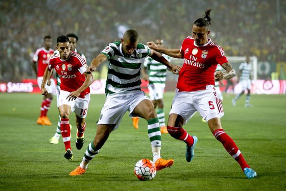 epa04878682 Benfica player Ljubomir Fejsa (R) vies for the ball with Islam Slimani (C) of Sporting Clube de Portugal during the 'Candido de Oliveira' Supercup match held at Algarve Stadium in Faro, Portugal, 09 August 2015. EPA/JOSE SENA GOULAO