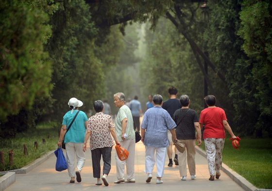 This photo taken on June 28, 2011 shows elderly women heading for their early morning exercises in Ditan Park in Beijing. China's population is ageing and flocking to cities, according to the latest national census results released recently, showing the world's most populous country now counted at 1.339 billion people. AFP PHOTO / Peter PARKS (Photo credit should read PETER PARKS/AFP/Getty Images)