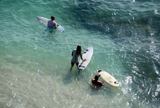 Surfers prepare to ride a wave off Uluwatu, in the south of Indonesia's resort island of Bali on June 26, 2015. Surfers are anticipating bigger waves than usual in the coming days off the island and Western Australia due to a storm in the Indian Ocean.  AFP PHOTO / SONNY TUMBELAKA        (Photo credit should read SONNY TUMBELAKA/AFP/Getty Images)