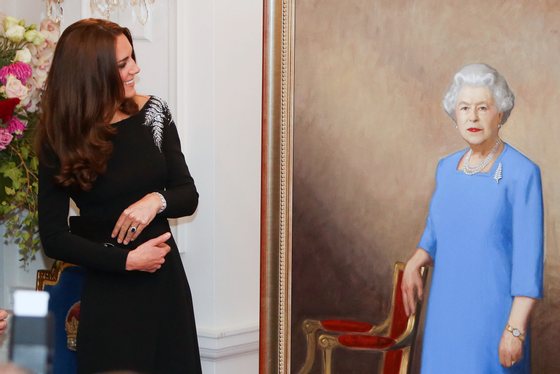 WELLINGTON, NEW ZEALAND - APRIL 10: Catherine, Duchess of Cambridge inspects a portrait of Queen Elizabeth II, painted by New Zealand artist Nick Cuthell and unveiled during a state reception at Government House on April 10, 2014 in Wellington, New Zealand. The Duke and Duchess of Cambridge are on a three-week tour of Australia and New Zealand, the first official trip overseas with their son, Prince George of Cambridge. (Photo by Hagen Hopkins/Getty Images)
