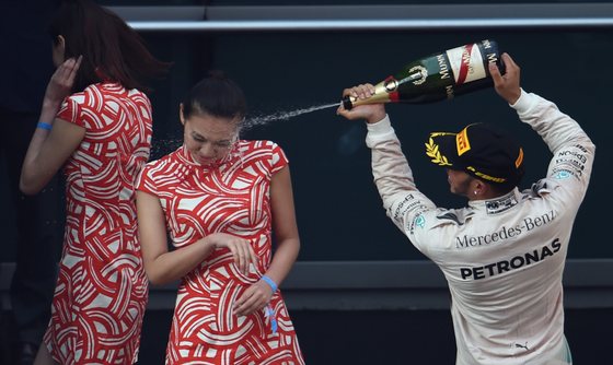 Mercedes AMG Petronas F1 Team's British driver Lewis Hamilton (L) sprays champagne as he celebrates on the podium after his victory in the Formula One Chinese Grand Prix in Shanghai on April 12, 2015. AFP PHOTO / JOHANNES EISELE (Photo credit should read JOHANNES EISELE/AFP/Getty Images)