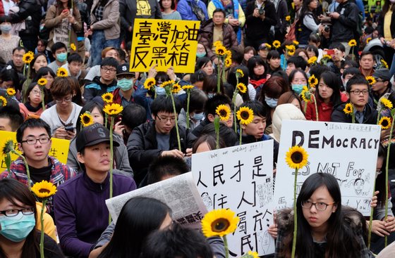 Students display flowers and placards during ongoing protests by thousands of people outside the parliament in Taipei on March 22, 2014. Student protesters occupying Taiwan's legislature to stop the government from ratifying a contentious trade pact with China on March 21 called on the public to surround the ruling party's offices after their ultimatum was ignored. AFP PHOTO / Sam Yeh (Photo credit should read SAM YEH/AFP/Getty Images)