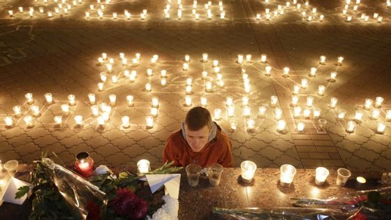 A man looks at candles and flowers in Simferopol on November 1, 2015 in memory of the victims of a jetliner crash. Russia mourned its biggest ever air disaster after a passenger jet full of Russian tourists crashed in Egypt's Sinai, killing all 224 people on board. A Russian airliner that crashed in Egypt broke up "in the air", an investigator said on November 1, as the bodies of many of the 224 people killed on board were flown home. AFP PHOTO / MAX VETROV (Photo credit should read MAX VETROV/AFP/Getty Images)