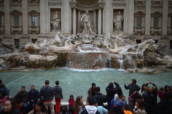 ROME, ITALY - MARCH 25: Tourists visit the Trevi Fountain on March 25, 2013 in Rome, Italy. Pope Francis yesterday led his first mass of Holy Week as pontiff by celebrating Palm Sunday in front of thousands of faithful and clergy. (Photo by Jeff J Mitchell/Getty Images)