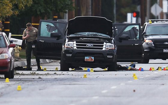 SAN BERNARDINO, CA - DECEMBER 03: Law enforcement officials investigate around the Ford SUV vehicle that was the scene where suspects of the shooting at the Inland Regional Center were killed on December 3, 2015 in San Bernardino, California. Police continue to investigate a mass shooting at the Inland Regional Center in San Bernardino that left at least 14 people dead and another 17 injured on December 2nd. (Photo by Joe Raedle/Getty Images)