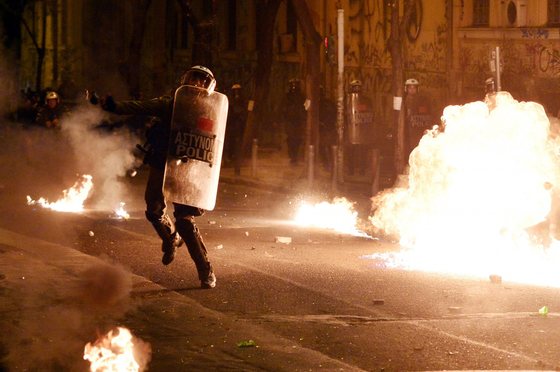 A police officer throws a tear gas grenade towards protesters throwing molotov cocktails during clashes in Athens on December 6, 2015. Anarchists turned part of central Athens into a battleground during a march to mark the seventh anniversary of the fatal shooting of 15-year-old boy by police. Alexis Grigoropoulos was shot dead by police on December 6, 2008 sparking weeks of riots. / AFP / LOUISA GOULIAMAKI        (Photo credit should read LOUISA GOULIAMAKI/AFP/Getty Images)