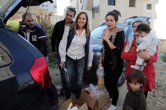 Os refugiados sÃ­rios, Tania Karban (C), Joelle (2D) e Bashir (E) e Nazeer Zeitour, trabalham para a JRS e ajudam e distribuem bens alimentares a outros refugiados do seu paÃ­s. (19 de novembro de 2015). NUNO VEIGA/LUSA